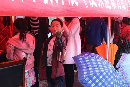 因為雨下的太大，小男孩玩起了接水游戲。