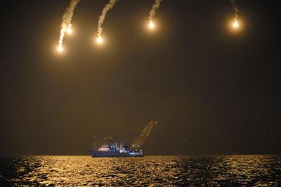 22日，搜救人員在照明彈的光亮下連夜搜救。