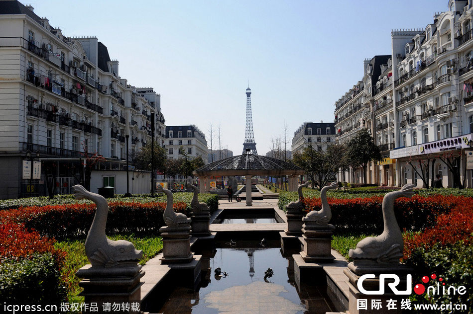 　2014年3月21日，杭州天都城，農(nóng)民在山寨埃菲爾鐵塔下耕作。圖片來源：東方IC