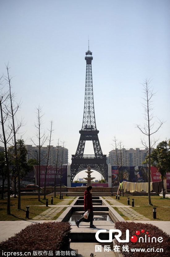 　2014年3月21日，杭州天都城，農(nóng)民在山寨埃菲爾鐵塔下耕作。圖片來源：東方IC