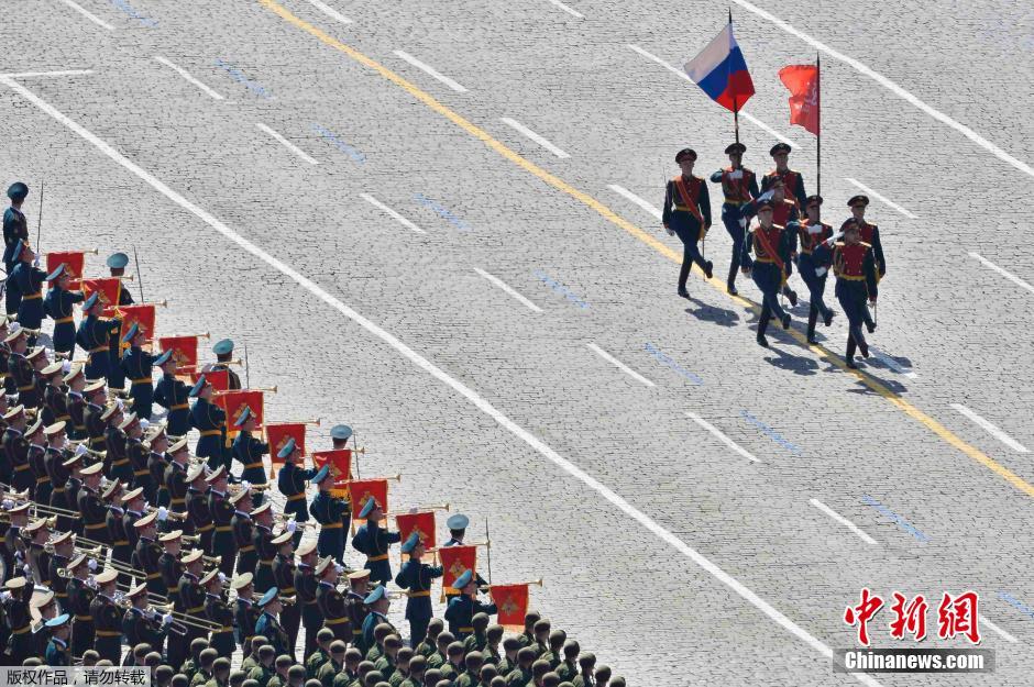 圖為俄羅斯國旗從受閱部隊(duì)前經(jīng)過。