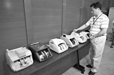 昨日，央行工作人員用各種驗(yàn)鈔機(jī)對(duì)C1F9假幣進(jìn)行測(cè)試，機(jī)器均能及時(shí)作出異常報(bào)警反應(yīng)。新京報(bào)記者 浦