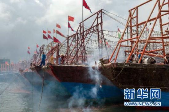 2013年8月1日 南海開漁日 臨高迎新港 8月1日，海南省臨高縣漁民在船上鳴放鞭炮慶祝武蓮港開港。