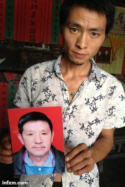 程興貴的兒子程正鵬拿著父親的遺照。程興貴自殺后，政府補償程家6000多塊錢，并終于認定了程興貴的代課教齡。 (南方周末記者雷磊/圖)