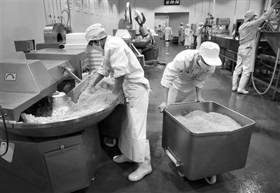 昨日，位于順義李遂開發(fā)區(qū)的慶豐包子鋪配送中心生產(chǎn)車間，工人們正在斬拌胡蘿卜餡料。