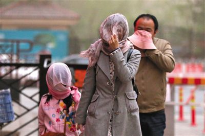 昨日下午，朝陽(yáng)區(qū)豆各莊，行人將紗巾裹在頭上防沙塵。