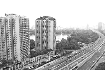 昨日，人濟(jì)山莊小區(qū)，與其他樓相比，B棟樓頂層天臺上違規(guī)建造了一棟兩層小樓，假山大樹俱全。新京報記者