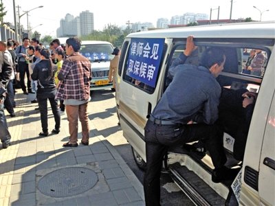 昨日，朝陽區(qū)看守所門前有人排隊。大門外還停有多輛寫有“律師會見”字樣的車。