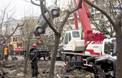 輸油管道爆炸后，搶修人員將被炸毀的車輛運(yùn)出現(xiàn)場(chǎng)。