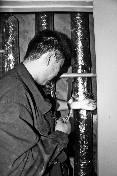 苗師傅一邊進行維修，一邊用耳機接聽市民的電話。