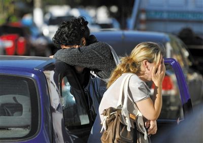 27日，遇難者親友在火災(zāi)現(xiàn)場旁哭泣。