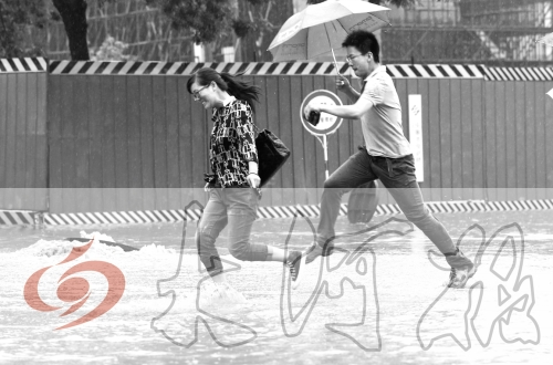 鄭州經(jīng)三路與北環(huán)交叉口處，積水較深，行人們不得不“練輕功”。 記者 白周峰 攝影