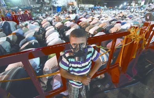 當(dāng)?shù)貢r間28日晚，在埃及開羅納賽爾城，一名小男孩頭戴防毒面具參加穆兄會的集會示威。