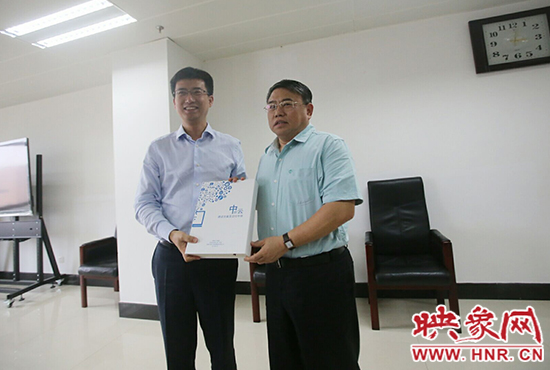 阿里云計(jì)算總裁胡曉明向河南省新聞出版廣電局局長(zhǎng)朱夏炎遞交《中原云平臺(tái)交付手冊(cè)》。