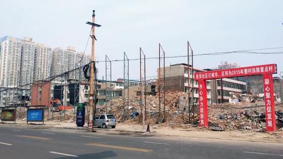 015年5月31日，在社區(qū)干部的帶頭拆遷下，親賢社區(qū)的“城中村改造”拉開帷幕。由于前期“清產(chǎn)核資”及補(bǔ)償標(biāo)準(zhǔn)等因素，拆遷改造工作推進(jìn)并不順利。圖為位于體育西路東側(cè)集體所有的商鋪率先被拆遷完畢，用于遮擋的圍擋正在施工中。（拍攝：2015年9月16日）