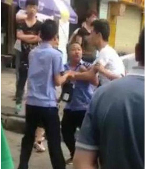 付某（右）與城管執(zhí)法人員廝打在一起。