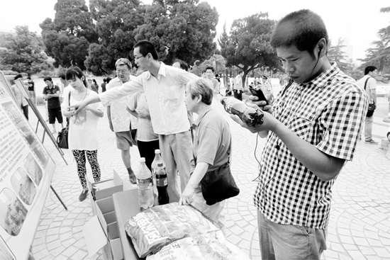 一位市民拿手機(jī)掃描商品條形碼,以確認(rèn)真?zhèn)? alt=