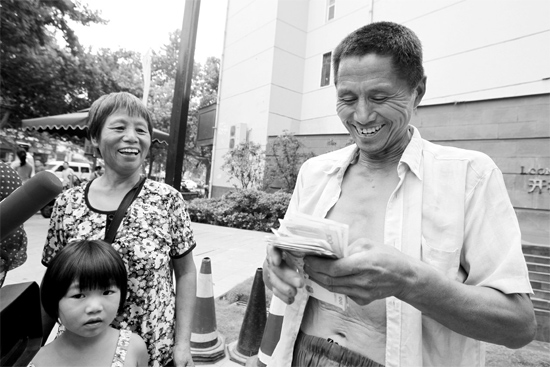 昨日，鄭州市明達(dá)路與豐慶路交叉口西300米路南，來自中牟的瓜農(nóng)拿到西瓜款，笑開顏東方今報記者袁曉強