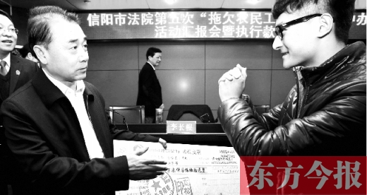 張立勇將依法執(zhí)行回來的農(nóng)民工工資發(fā)放給案件當(dāng)事人游昌華，游昌華施以中國傳統(tǒng)作揖禮答謝