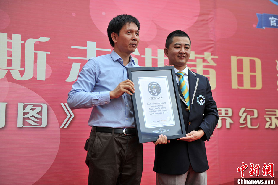 圖為世界吉尼斯認(rèn)證官為鄭春輝（左）頒發(fā)證書。呂明 攝