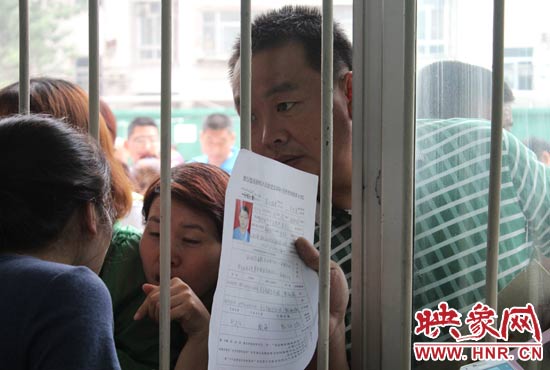 不少家長擠在報名窗口前咨詢報名事宜。