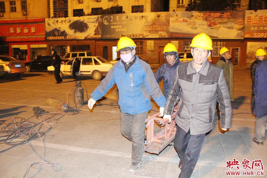 23點56分，第一塊兒廣告牌已經(jīng)分割完畢，地面上的20多名工人將拆除下來的鋼件撞車運走。