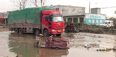 老人的電動(dòng)三輪車還陷在泥坑中 老人的電動(dòng)三輪車還陷在泥坑中