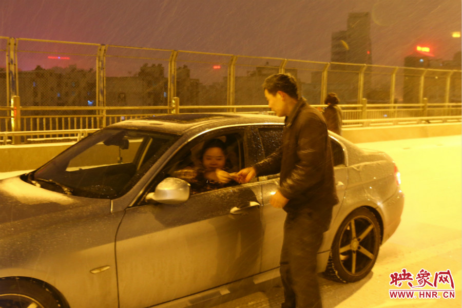 “推車(chē)人”幫助一輛車(chē)上坡后，收取“勞務(wù)費(fèi)”。