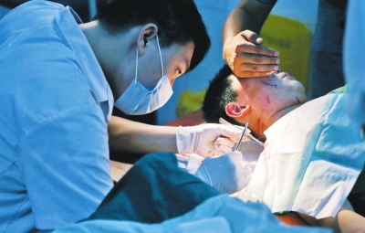 孩子身上有7道傷痕，其中兩道需要縫合，其他的均為擦傷，醫(yī)生正對他施治。