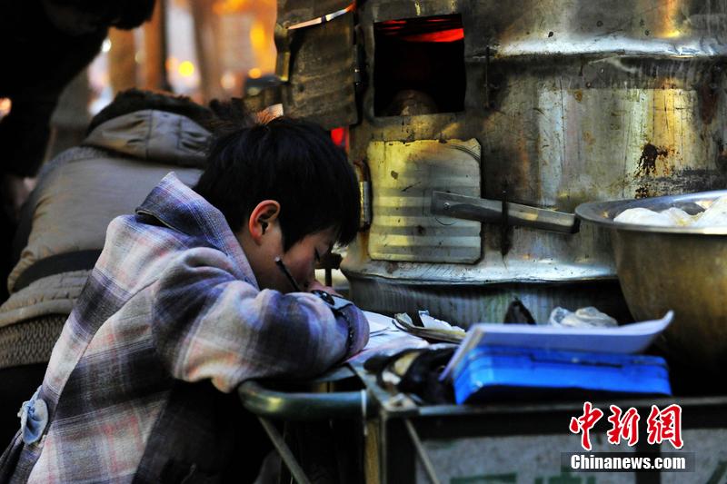 男孩西安路燈下寫作業(yè) 媽媽邊賣紅薯邊輔導(dǎo) 男孩西安路燈下寫作業(yè) 媽媽邊賣紅薯邊輔導(dǎo)