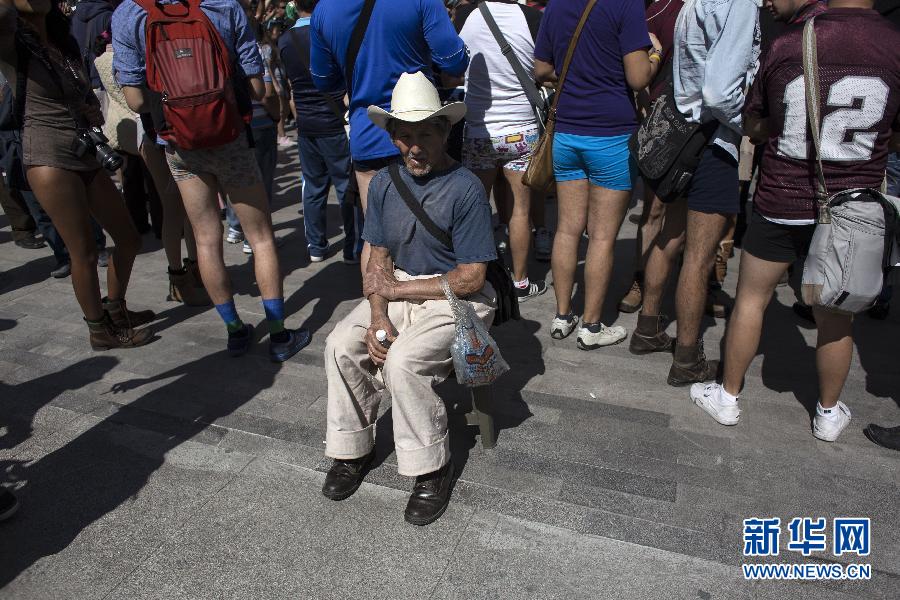 一名男子坐在參加不穿褲子搭地鐵的人群邊小憩。