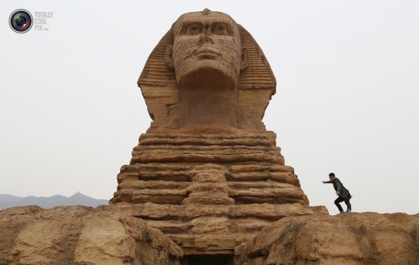 石家莊郊外，一名男子與山寨版獅身人面像合影留念。