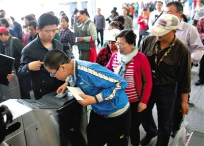 去年5月5日，14號線園博園站，乘客刷卡出地鐵。北京公交地鐵將實行計程票制，多乘坐多付費。