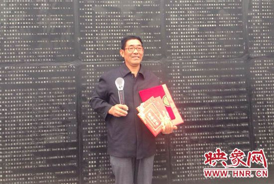 義務(wù)守陵員范欽憲手握榮譽(yù)證書(shū)