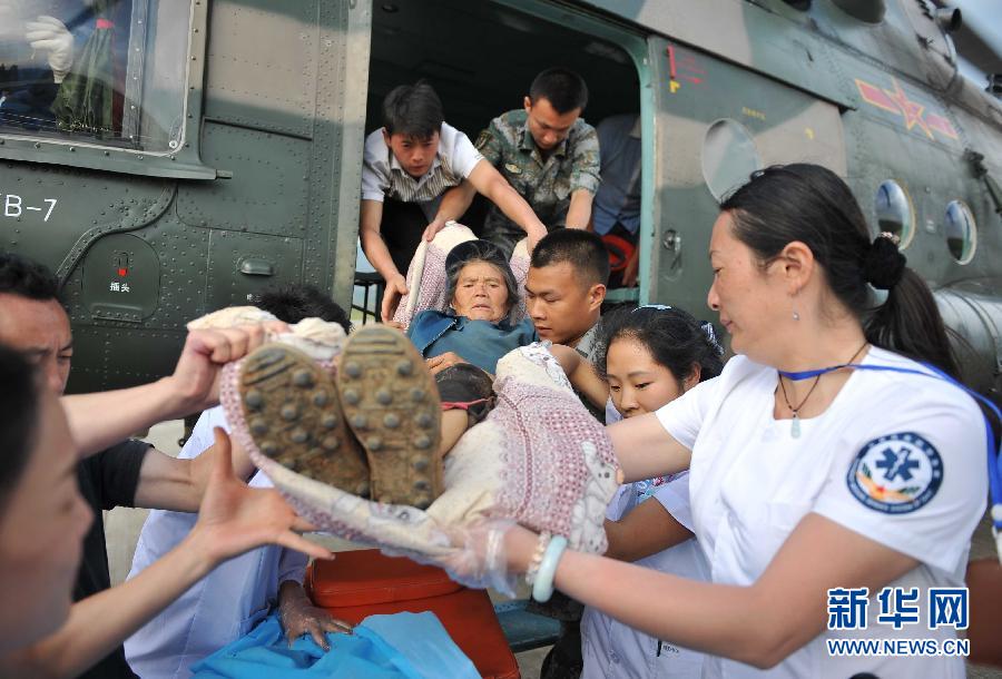 8月5日，醫(yī)護(hù)人員將一名通過直升機(jī)從震中轉(zhuǎn)運(yùn)出來的傷員運(yùn)下飛機(jī)。