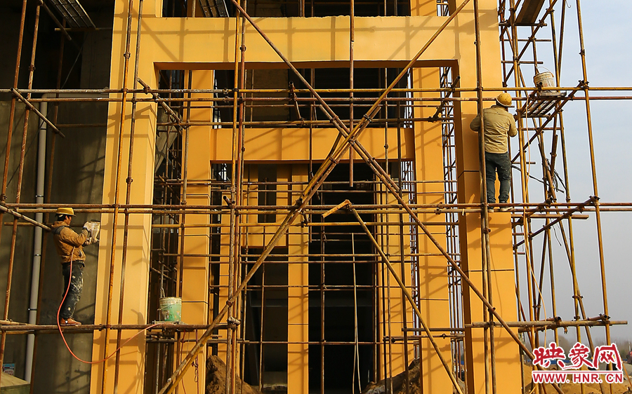 兩位工人正在對墻體進(jìn)行噴漆作業(yè)