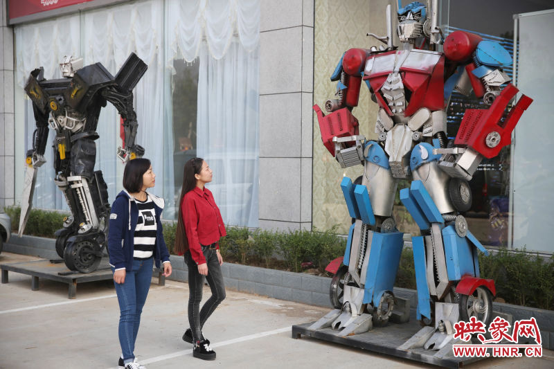 10月14日，市民在參觀河南省平頂山市寶豐縣一家企業(yè)門前的“變形金剛”。