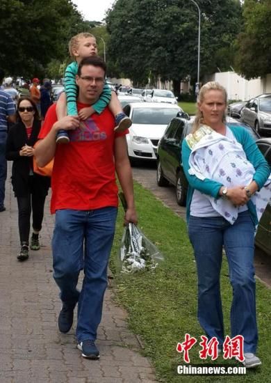 圖為一個白人家庭，由父母帶著孩子到曼德拉家門外悼念。中新社發(fā) 宋方燦 攝