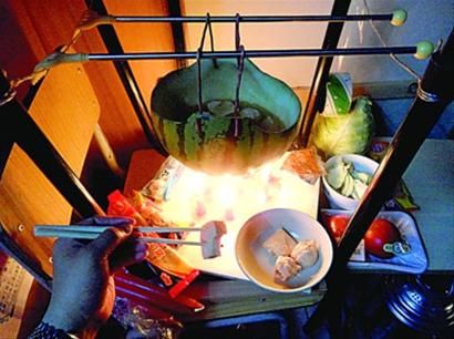 兩張椅子被面對(duì)面疊在一起，穿了兩根線的西瓜皮就懸空在椅腳中間，下面有蠟燭加熱，這就是西瓜火鍋。