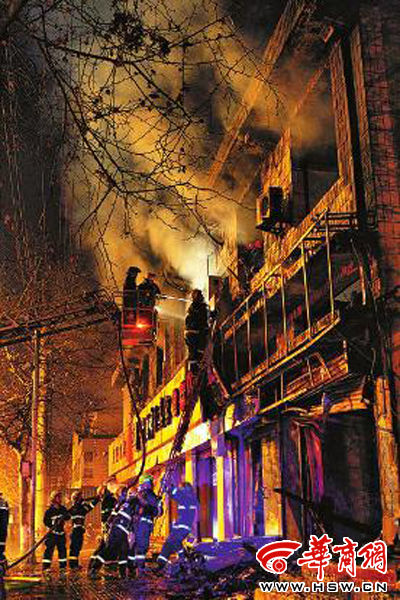 昨日22時(shí)10分，西安市豐慶路南小巷南口，消防官兵架梯子登上二樓施救 本組圖片由本報(bào)記者 閆文青 攝