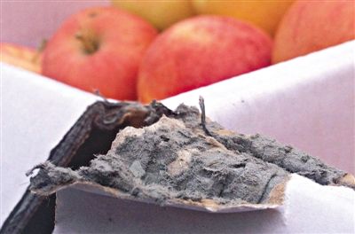 8月29日，新發(fā)地市場，一箱用“加重紙箱”包裝的蘋果正待售，紙箱夾層內灰黑色的增重填充物清晰可見