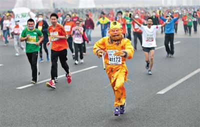 長(zhǎng)安街，一名打扮成孫悟空的參賽者在北馬隊(duì)伍里飛奔。 本版攝影/新京報(bào)記者 吳江 李飛 王嘉寧 吳江