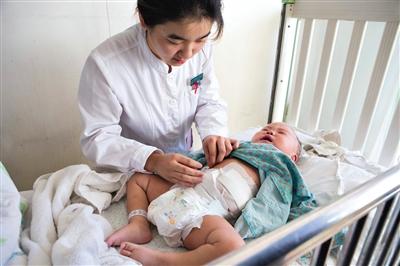 昨日，北京兒童醫(yī)院，護(hù)士為即將出院的被扎鋼針女嬰檢查傷口恢復(fù)情況。記者 高瑋 攝