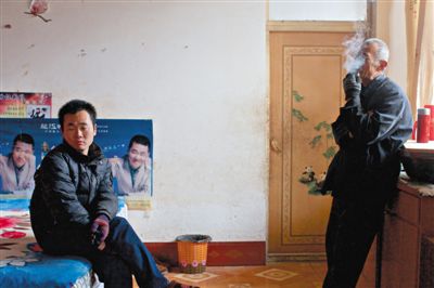 父親抽煙，兒子不語。逃跑的越南新娘，給袁迎賓父子帶來的是失落。新京報記者 周崗峰 攝