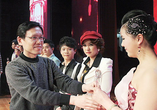 2013年2月1日，《對(duì)9當(dāng)歌》總決賽在鄭州開(kāi)唱。圖為東方今報(bào)副社長(zhǎng)胡楊為選手頒獎(jiǎng)