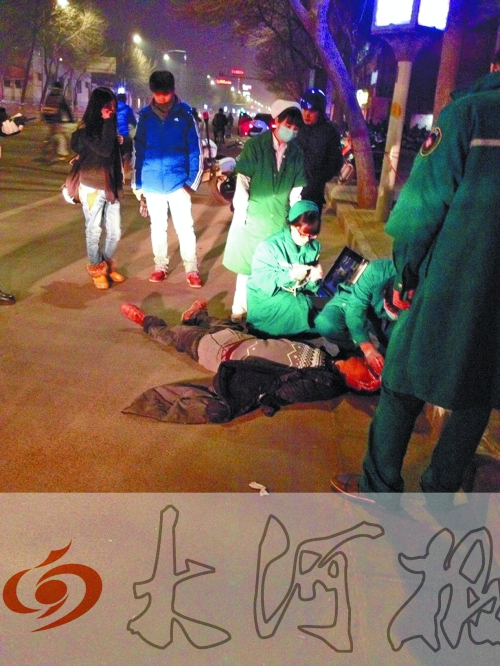 醉漢躺在地上，醫(yī)護(hù)人員對其進(jìn)行檢查。